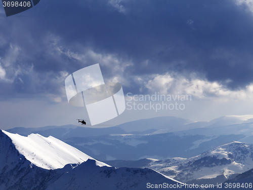 Image of Off-piste slope for heliskiing and helicopter in evening