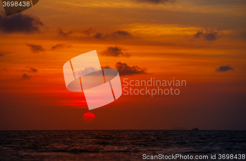 Image of Red Ball of the Sun Dipping towards Horizon at Sunset