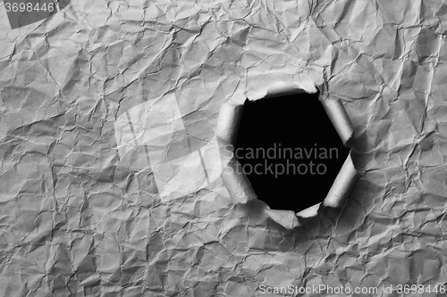Image of Gray sheet ofcrumpled paper with a hole