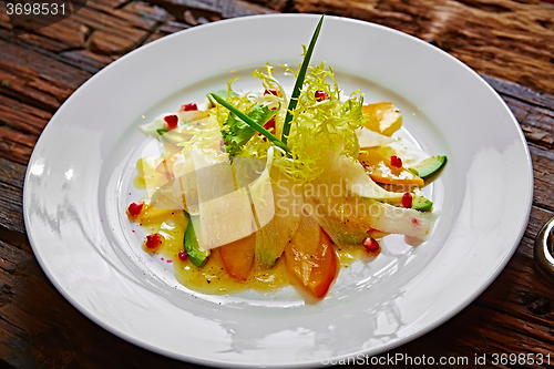 Image of salad of celery, avocado and persimmon with greens 