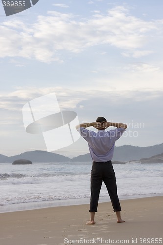 Image of Businessman relaxing on beach