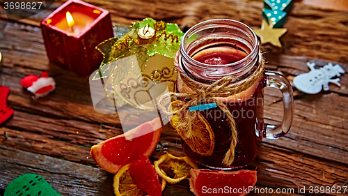 Image of Mulled wine and spices on wooden background. 