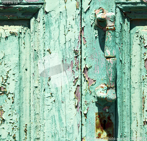 Image of spain canarias brass r in a green closed wood  door abstract 