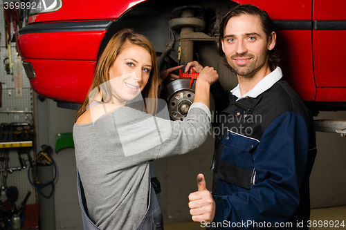 Image of Auto mechanic and female trainee in garage