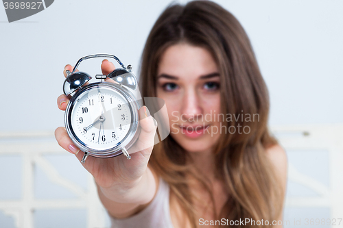 Image of The young girl in bed with  clock service