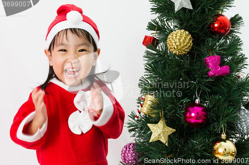 Image of Asian Chinese little girl posing with Christmas Tree