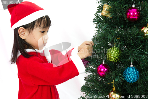 Image of Asian Chinese little girl posing with Christmas Tree