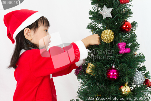 Image of Asian Chinese little girl posing with Christmas Tree