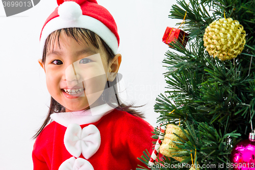 Image of Asian Chinese little girl posing with Christmas Tree