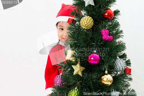 Image of Asian Chinese little girl posing with Christmas Tree