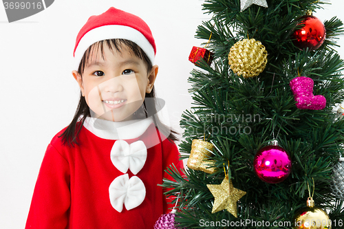 Image of Asian Chinese little girl posing with Christmas Tree