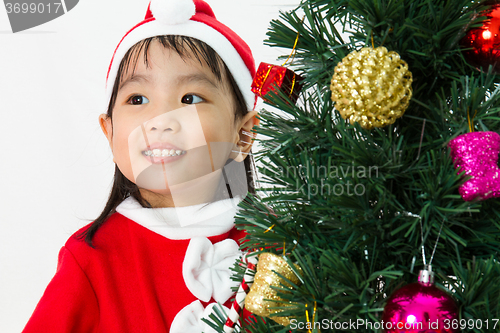 Image of Asian Chinese little girl posing with Christmas Tree