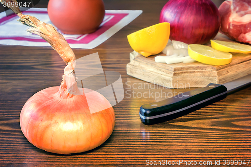 Image of The still life: large onion and lemon on the table.