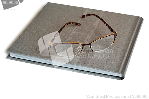 Image of Glasses and notebook on a white background.