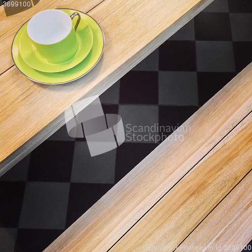 Image of Green cup on a wooden table