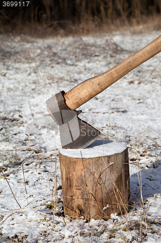 Image of Axe and log in winter forest