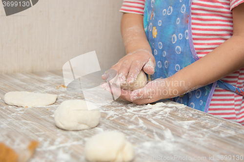 Image of Girl sculpts a pie, close-up