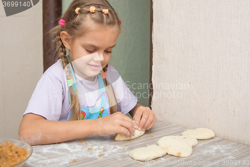 Image of Cheerful six year old girl sculpts cakes with cabbage