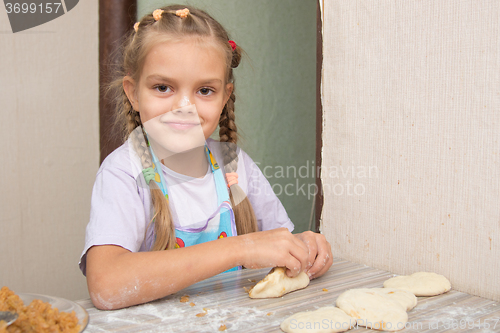 Image of Cheerful girl sculpts cakes with cabbage