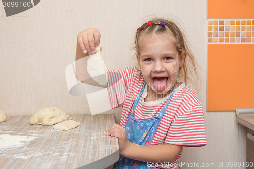 Image of Happy little girl blinded blank for cakes at the kitchen table