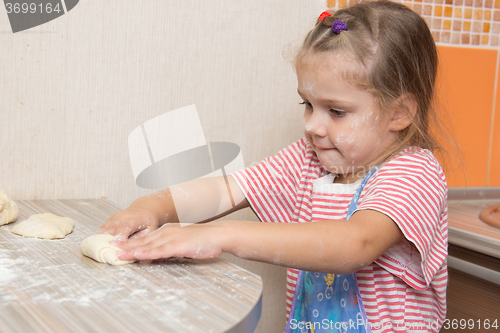 Image of Girl sculpts cakes at the kitchen table