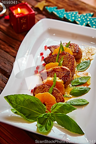 Image of Grilled pork with mandarin oranges decorated and basil 