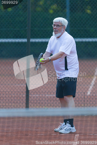 Image of Senior man playing tennis