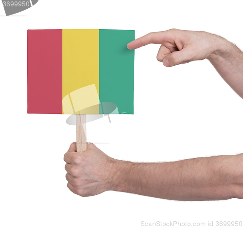 Image of Hand holding small card - Flag of Guinea