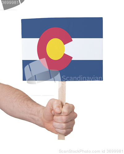 Image of Hand holding small card - Flag of Colorado