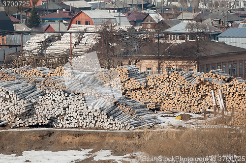 Image of pile of wood logs on plywood combine. Tyumen