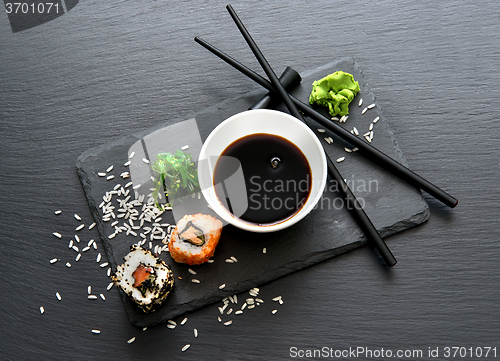 Image of Rolls with sauce and chopsticks