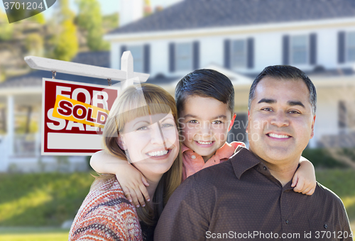 Image of Young Family in Front of Sold Real Estate Sign and House