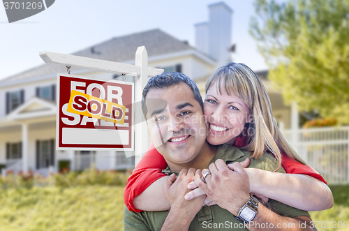 Image of Couple in Front of Sold Real Estate Sign and House