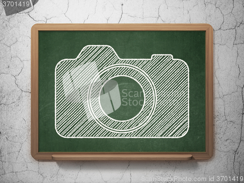 Image of Travel concept: Photo Camera on chalkboard background