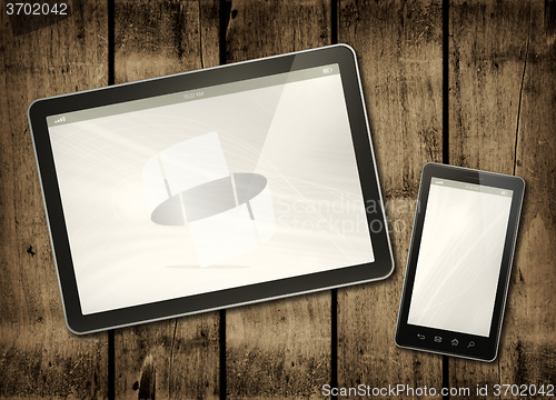 Image of Smartphone and digital tablet PC on a dark wood table