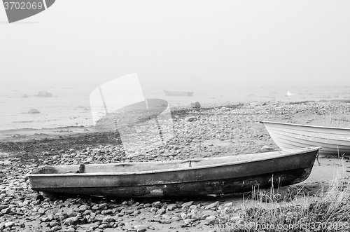 Image of Old fishing boat at coast foggy in the morning
