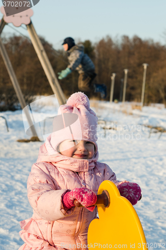 Image of  Children swinging on a swing in winter