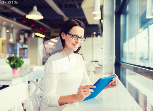 Image of smiling woman with tablet pc at cafe