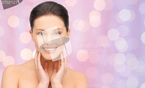 Image of beautiful young woman touching her face and neck