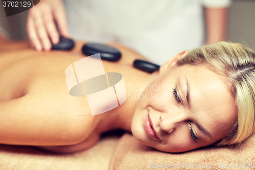 Image of close up of woman having hot stone massage in spa