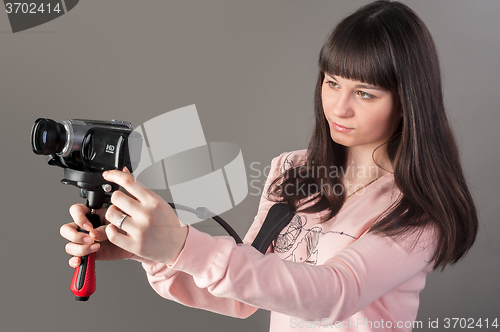 Image of Young pretty woman with video camera