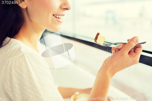 Image of close up of woman eating cake at cafe or home