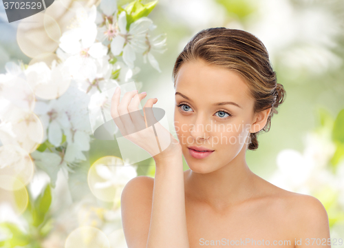 Image of woman smelling perfume from wrist of her hand