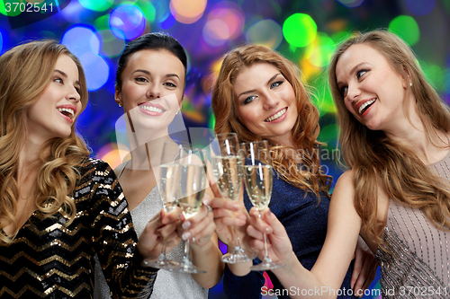 Image of happy women clinking champagne glasses over lights