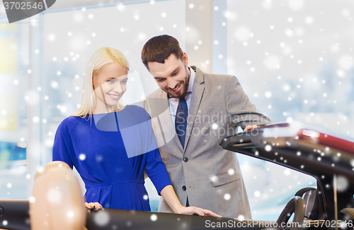 Image of happy couple buying car in auto show or salon