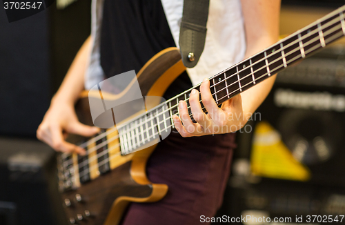 Image of close up of musician with guitar at music studio