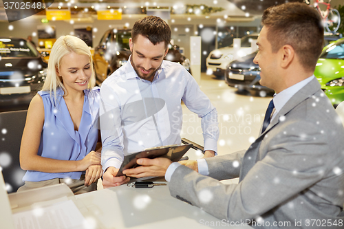 Image of happy couple with car dealer in auto show or salon