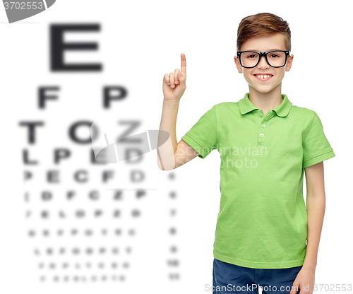 Image of happy boy in eyeglasses pointing finger up