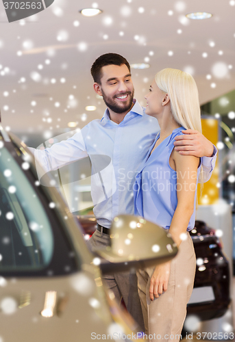 Image of happy couple buying car in auto show or salon