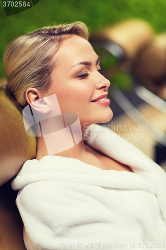 Image of close up of woman sitting in bath robe at spa